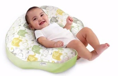 bebe tumbado sobre almohada de embarazada